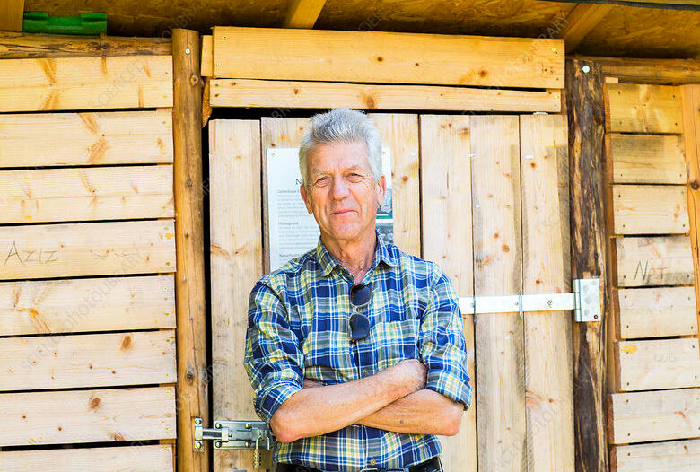 Man Outside Shed Man standing proud outside shed he built.